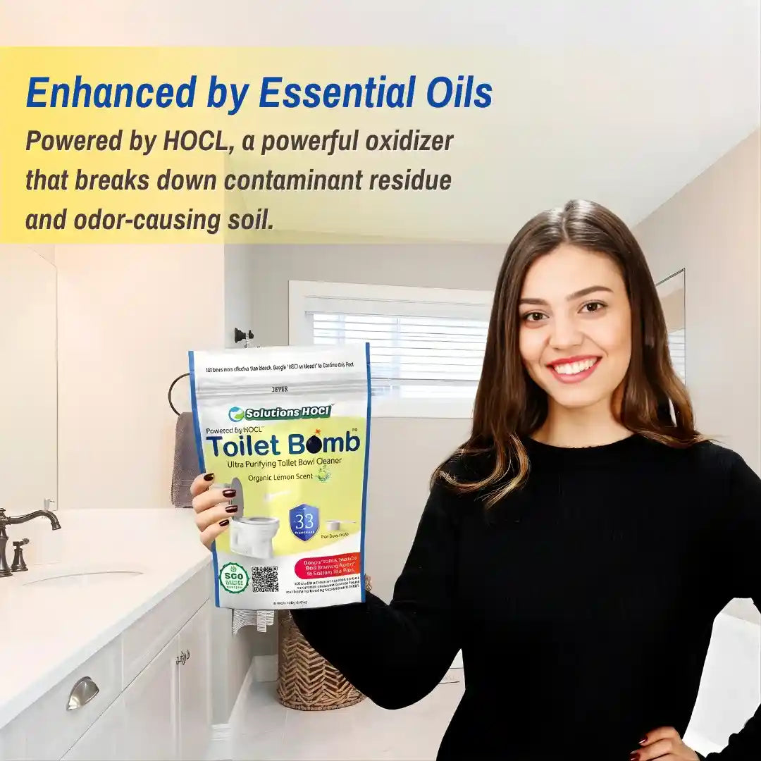 A woman in a black long-sleeve top holds a bag of HOCL Toilet Bomb in a bright bathroom setting.